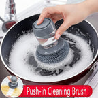 Push-in cleaning brush being used to clean a soapy pan with a close-up inset showing the brush.